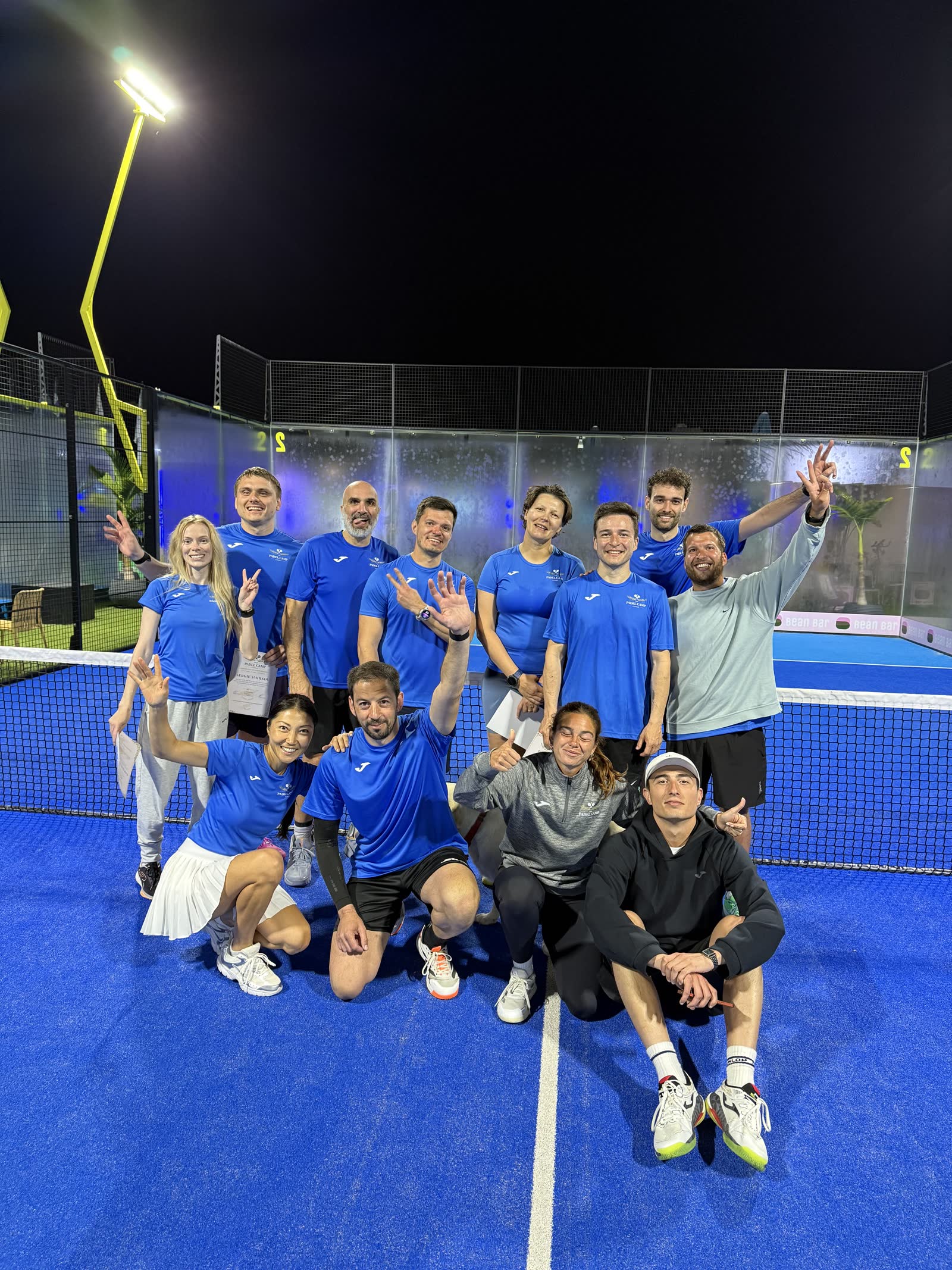 Padel Camp Cyprus participants celebrating together at night on court