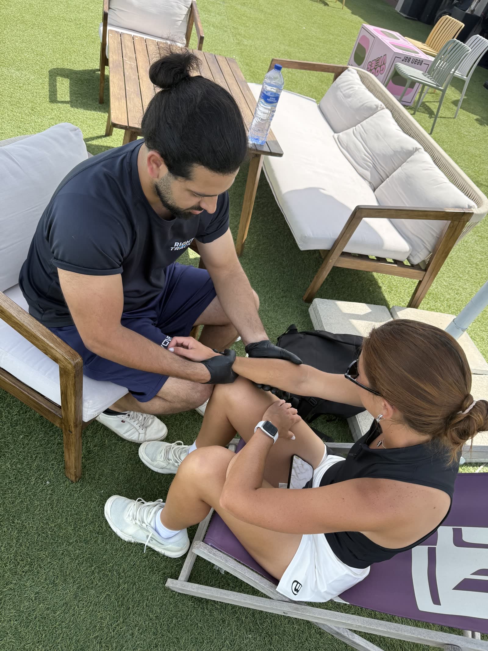 Right Track sports physiotherapist treating a player courtside at Padel Camp Cyprus